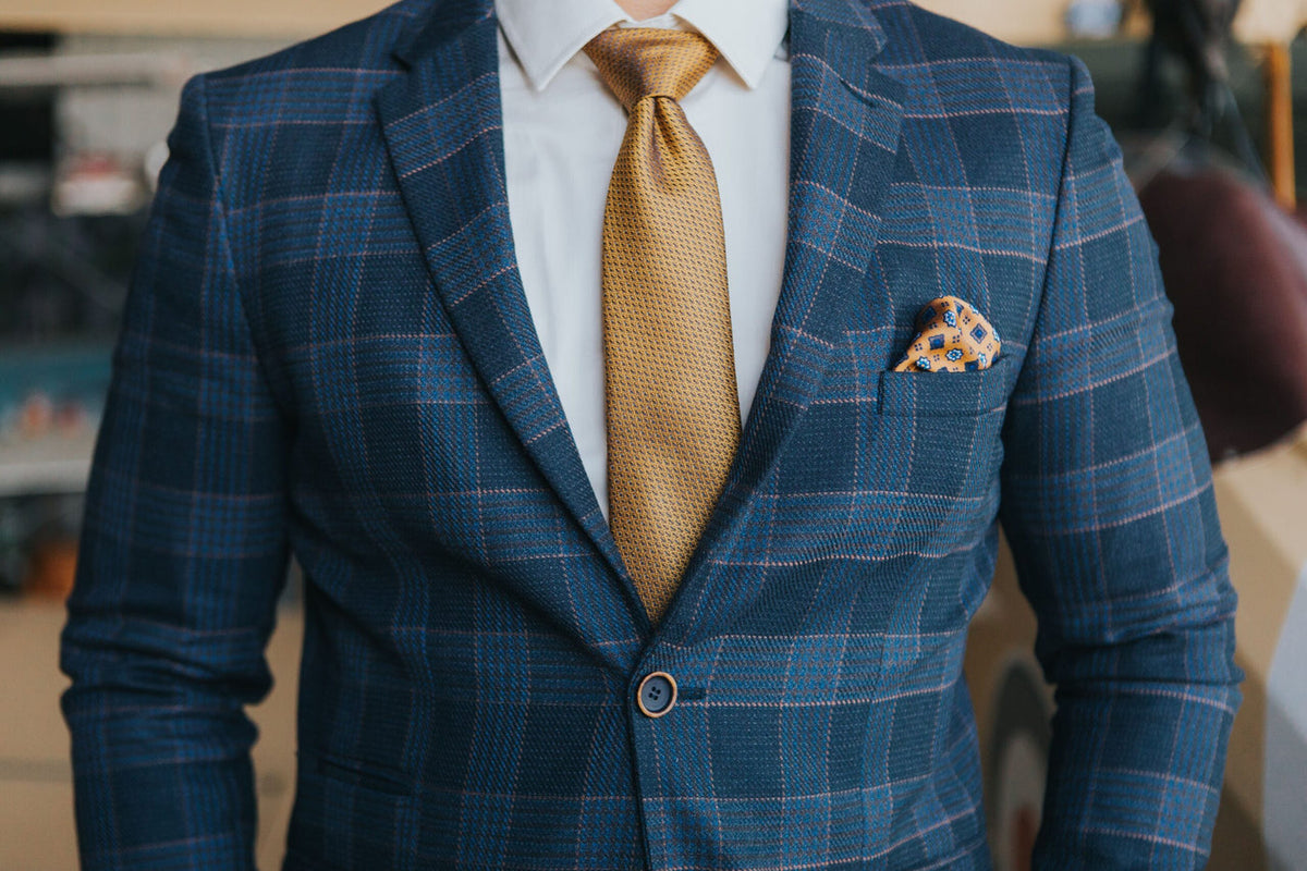 Close-up of the fabric and pattern of a blue plaid suit